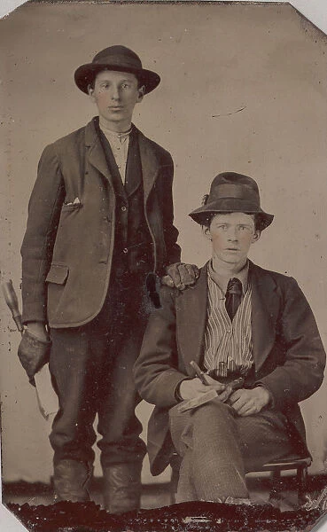 Two Young Men, One Seated and One Standing, Holding Carpentry Tools, 1870s-90s