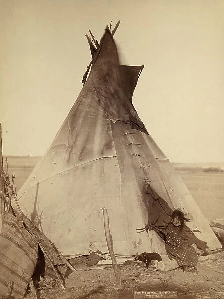 A young Oglala girl sitting in front of a tipi, with a puppy.... Pine Ridge Reservation, 1891. Creator: John C. H. Grabill