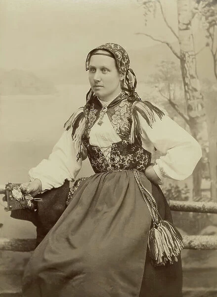 A young woman poses in a folk costume, 1890-1920. Creator: Helene Edlund
