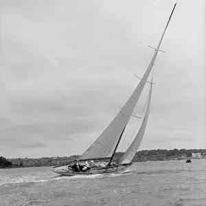 12 Metre class sailing yacht heeling over in windy conditions on upwind leg, 1938
