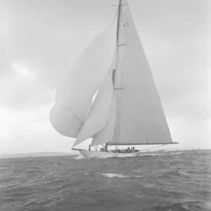 The 23-metre cutter Astra sailing with spinnaker, 1932. Creator: Kirk & Sons of Cowes