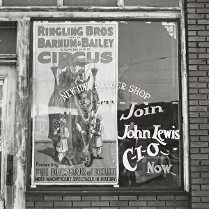 Barber shop window [with circus poster] in Birmingham, Alabama, 1937-01 - 1937-02. Creator: Arthur Rothstein