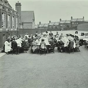 Children eating dinner at tables in the playground, Shrewsbury House Open Air School, London, 1908