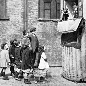 Children watching a Punch and Judy show in a London street, 1936. Artist: Donald McLeish