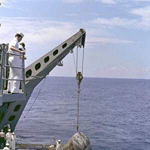 Gemini 5 capsule hoisted onboard recovery ship, 1965. Creator: NASA