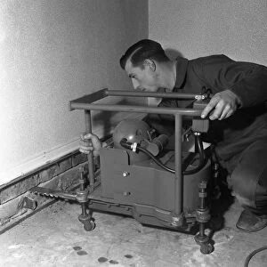 Installing a damp proof course in a house in Goldthorpe, South Yorkshire, 1957. Artist