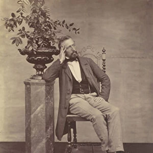 [Mathias Housermann seated with elbow on pedestal holding a vase of flowers]