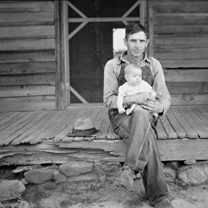 Mr. Whitfield, tobacco sharecropper with baby... North Carolina, Person County, 1939. Creator: Dorothea Lange