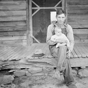 Mr. Whitfield, tobacco sharecropper, with baby on front porch, North Carolina, Person County, 1939. Creator: Dorothea Lange