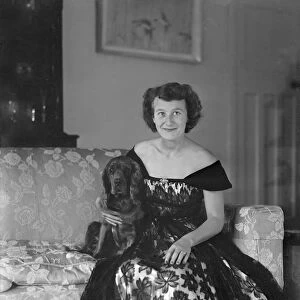Portrait of seated woman in evening dress with her dog, c1935. Creator: Kirk & Sons of Cowes