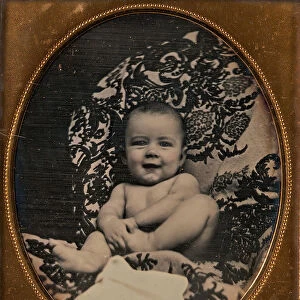 [Smiling, Nude Baby Holding Foot, Seated on Furniture Draped with Floral Print Fabric]