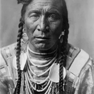 Strike On his Head, Crow Indian, Montana, head-and-shoulders portrait, facing front, loose... c1908 Creator: Edward Sheriff Curtis