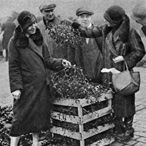 Women choosing bunches of mistletoe, Caledonian Market, London, 1926-1927