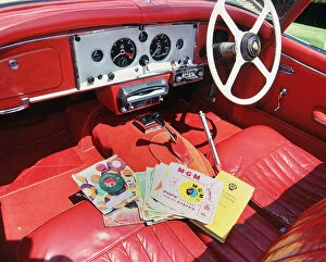Seat Gallery: 1960 Jaguar XK150 interior with record player and 7inch vinyl discs.. Creator: Unknown