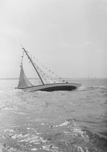 The 7 Metre Ginerva (K7) under sail with prize flags, 1912. Creator: Kirk & Sons of Cowes