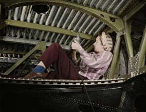Douglas Aircraft Company Gallery: An A-20 bomber being riveted by a woman...Douglas Aircraft Company plant at Long Beach, Calif