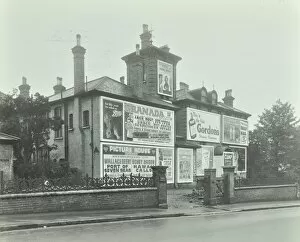 Greater London Council Gallery: Advertising hoardings on the wall of a building, Wandsworth, London, 1938
