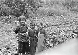 Young Girl Prints: Three Ainu children standing in a garden, 1908. Creator: Arnold Genthe