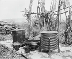 Containers Prints: Ainu man seated outdoors on a mat covered with clay containers