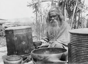 Containers Prints: Ainu man seated outdoors on a mat covered with clay containers