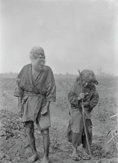 Aino Prints: Ainu man and woman standing outside, 1908. Creator: Arnold Genthe