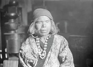 Aino Prints: Ainu woman wearing a headscarf, earrings, and a necklace, 1908. Creator: Arnold Genthe