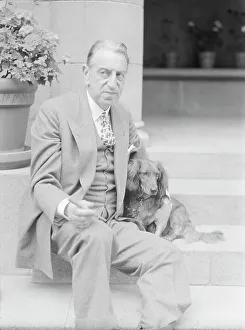Stockbroker Prints: Alanson, Bertram, Mr. with dog, seated on steps, 1927 Creator: Arnold Genthe