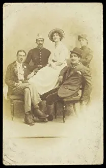 Cross Dressing Prints: Amateur actors sitting down, surrounding a man in drag seated in the centre