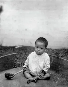Chicago World Fair Prints: Asian(?) baby seated holding spoon or ladle