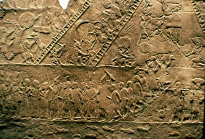 Assyrian warriors and besieging and destroying a city, in the lower register, capturing prisoners