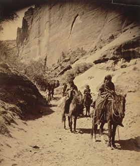 Canyon Collection: Band of mounted Navahos passing through Cañon, c1904. Creator: Edward Sheriff Curtis