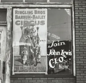 Barber shop window [with circus poster] in Birmingham, Alabama, 1937-01 - 1937-02. Creator: Arthur Rothstein