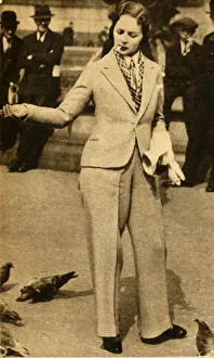 Henry Ewhite Gallery: A betrousered lady feeding pigeons in Trafalgar Square, 1933. Creator: Unknown