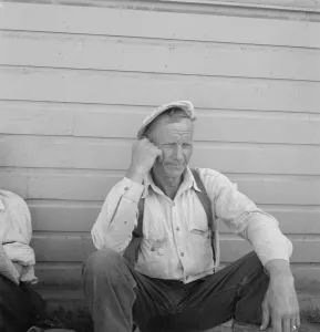 Bindle stiff, used to be logger, Side of Pastime Cafe, Tulelake, Siskiyou County, California, 1939. Creator: Dorothea Lange