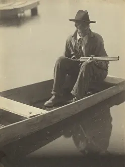 Shotgun Prints: Black Man in Flat Boat, Holding Shotgun, 1929-1930. Creator: Doris Ulmann