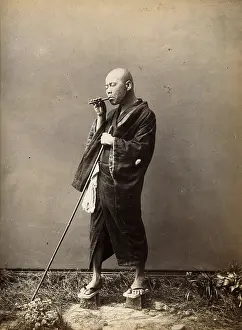 Sandal Prints: A blind Japanese masseur with a pipe in his mouth and a long pole in his hand
