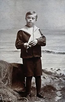 Fishing Net Prints: A boy with Down's syndrome, dressed in a sailor suit, standing against a nautical