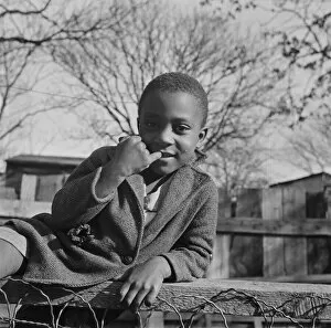 Fence Gallery: Boy playing on a fence, Washington (southwest section), D.C. 1942. Creator: Gordon Parks