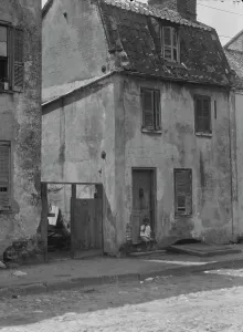 Two Storey Prints: Boy sitting in the doorway of a two-story building