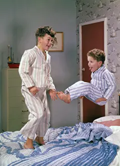 Two boys jumping on a bed, c1955. Creator: Arthur Charles Kirby Ware