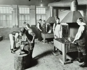Boys using forges in a blacksmiths shop, Beaufoy Institute, London, 1911