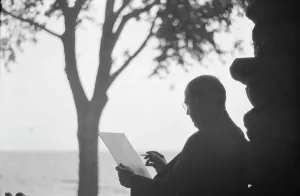 Bruce, Ned, Mr. reading and writing outdoors, 1915? Creator: Arnold Genthe