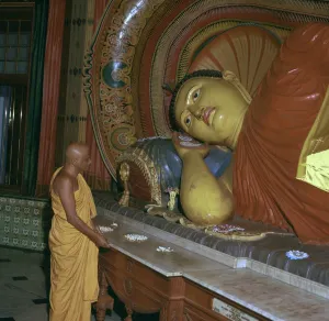 Buddhist priest before the image of a reclining Buddha