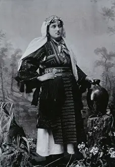 Balkan Prints: A Bulgarian woman in national dress with a water jug, early 20th century. Creator: Unknown