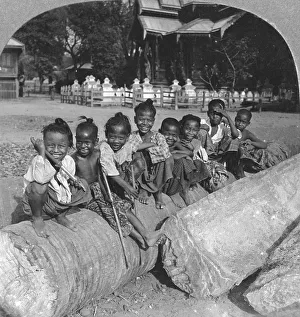 Stereo Travel Prints: Burmese children sitting on a palm log, Burma, 1908. Artist: Stereo Travel Co