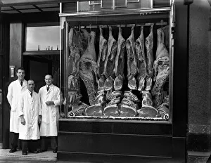 Food Industry Prints: Butchers standing next to their shop window display, South Yorkshire, 1955. Artist