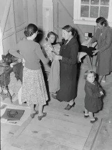 Needlewoman Prints: Camper receives help in fitting a coat from WPA sewing instructor