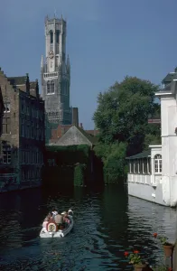 Canal, old houses, and the Belfrey of the Tour Des Halles in Bruges Canal, old houses, and the Belfrey of the Tour Des Halles in Bruges
