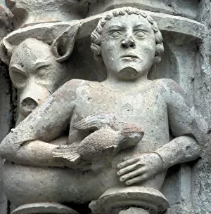 Detail of a capital showing a man with a pigeon in the hand, in the cloister of the