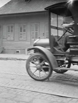 Car driving down a street, New Orleans or Charleston, South Carolina, between 1920 and 1926. Creator: Arnold Genthe